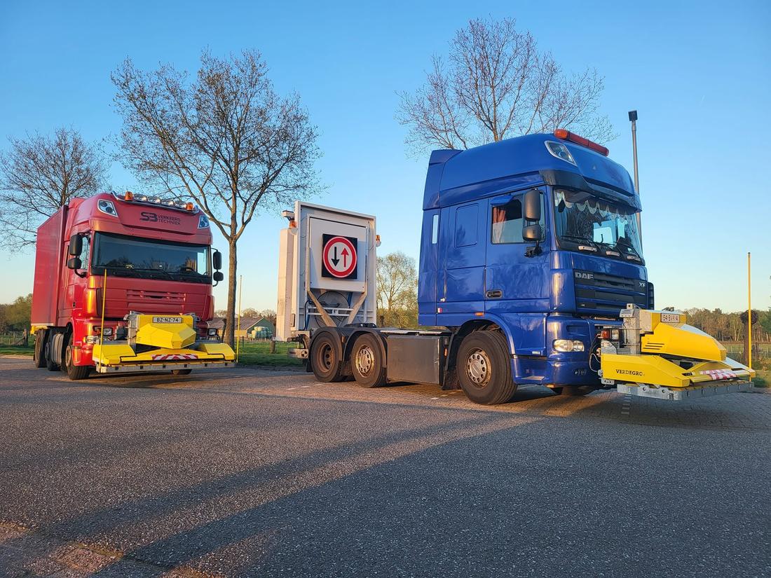 Rode en blauwe DAF-trucks van SB Verkeerstechniek met gele botsabsorbers